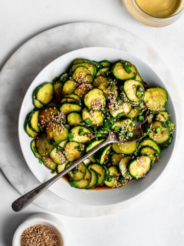 Asian Style Cucumber Salad garnished with garlic chives and sesame seeds