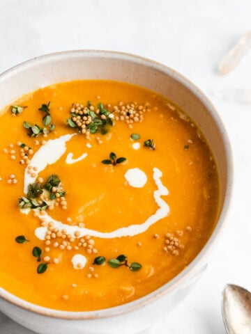 red curry squash soup garnished with mustard seeds and thyme