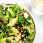 Celery salad with apples, shallots, parsley and walnuts on a flat plate