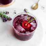 Cherry shrub shot from overhead, garnished with ice and fresh thyme
