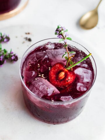 Cherry shrub shot from overhead, garnished with ice and fresh thyme