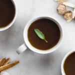 medicinal mushroom broth in a mug with a sage leaf
