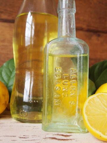 limoncello in glass bottle next to sliced lemons